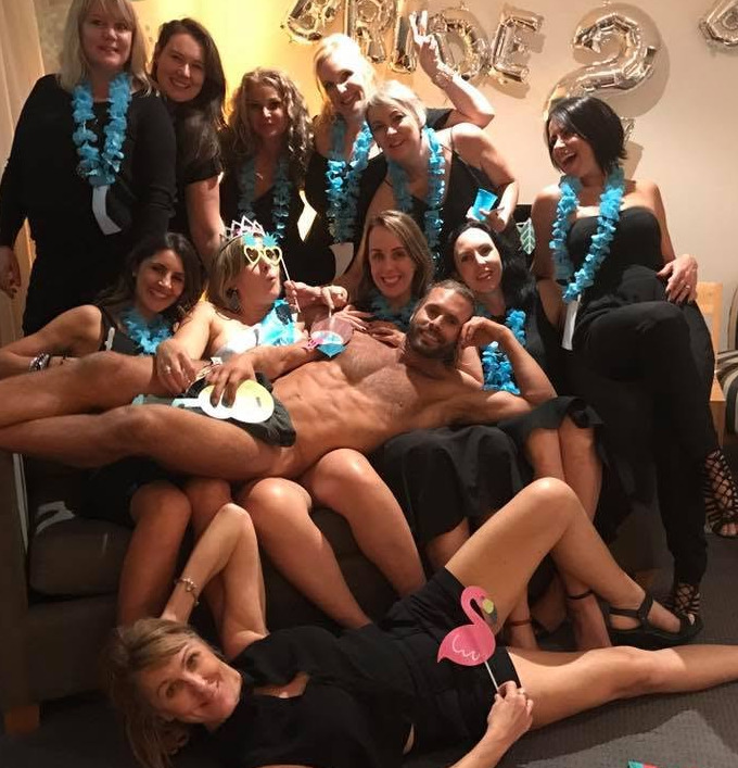 Hens in blue leis with the bride in a tiara and the model lying across their laps