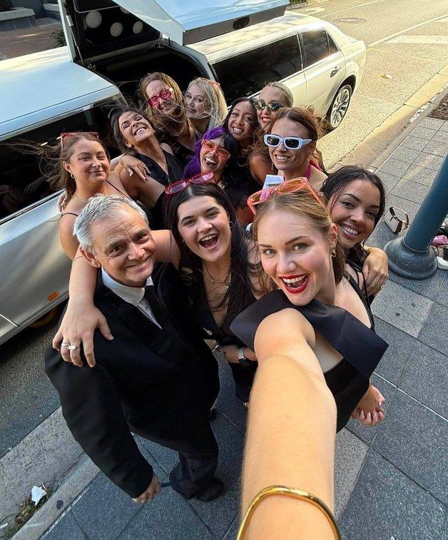 A group selfie beside the limousine