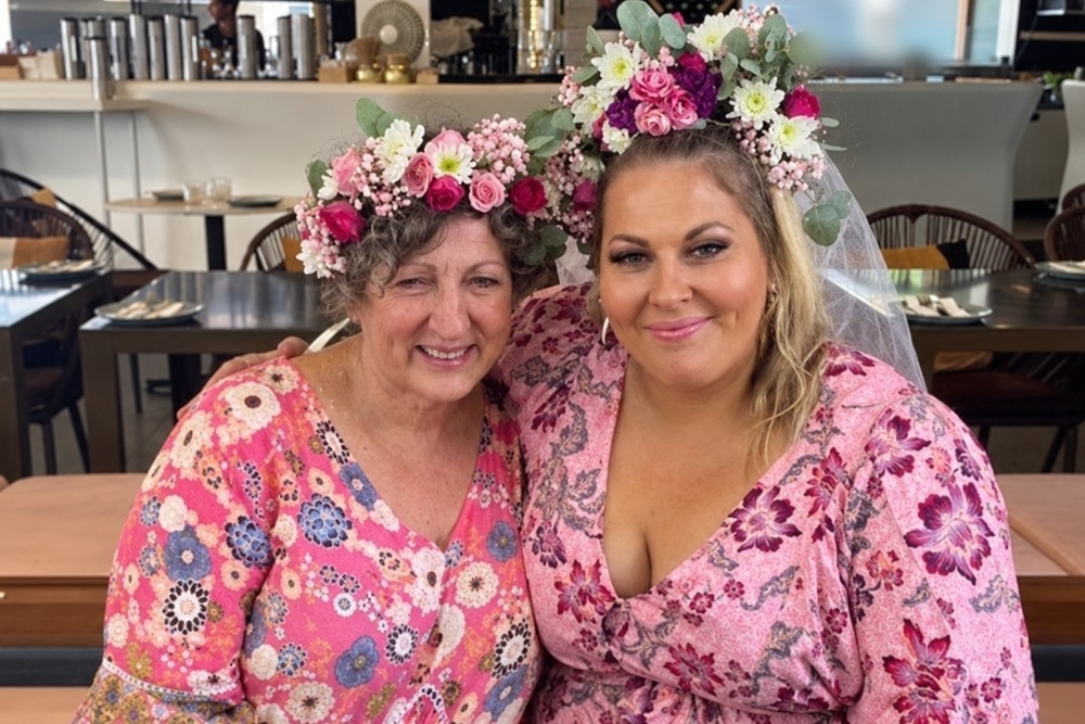 The bride and her mum smiling together in fresh flower crowns