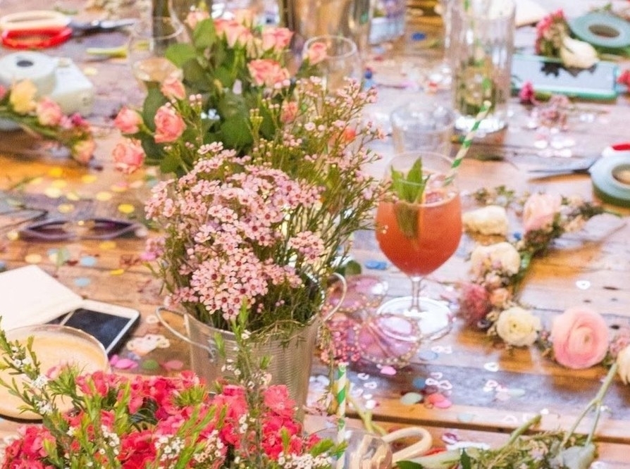 A cocktail among fresh blooms on the flower crown table