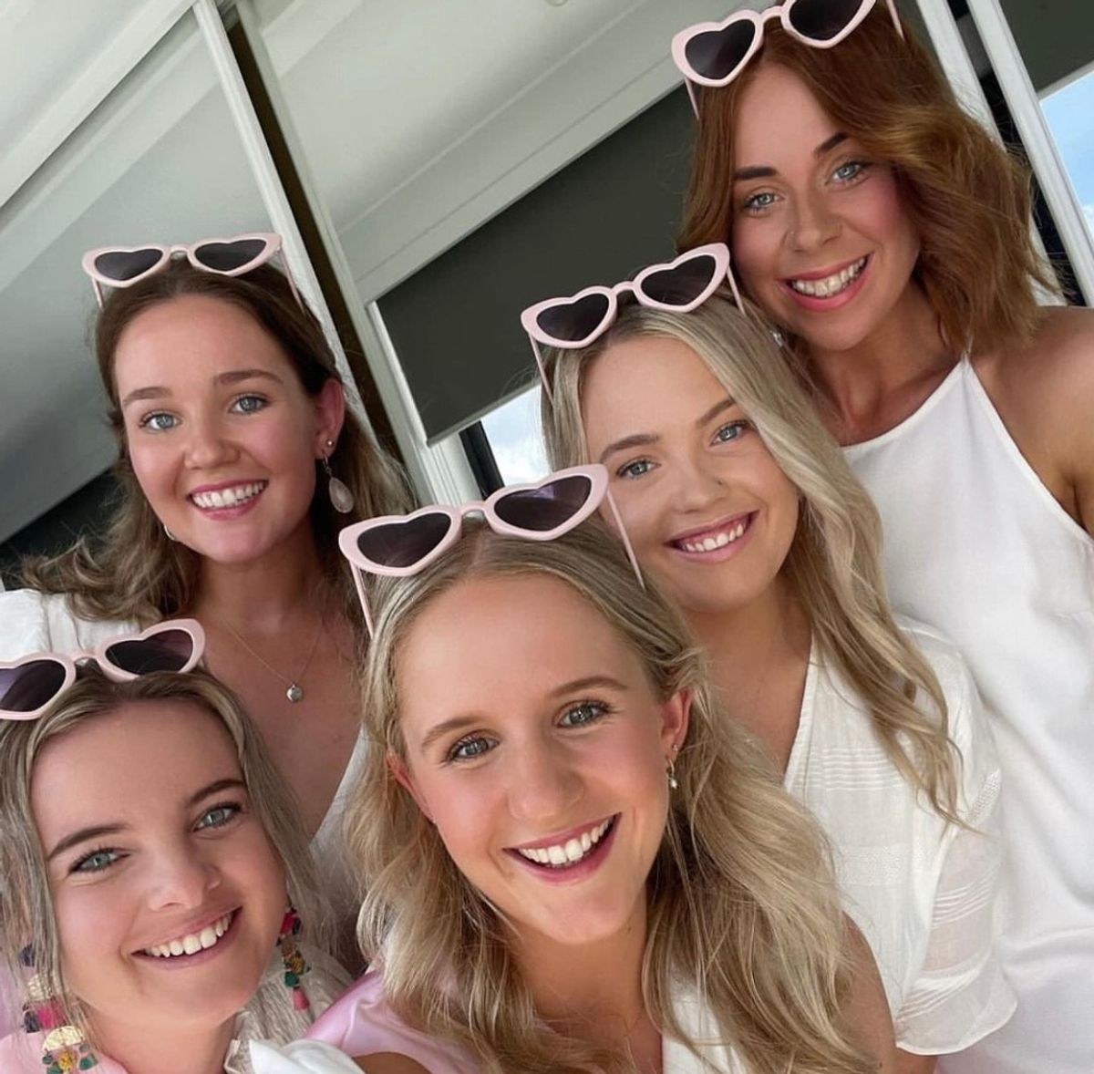 Five friends in heart sunglasses squeezed into one selfie