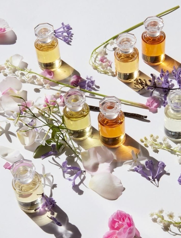 Little amber perfume bottles laid out with fresh flowers