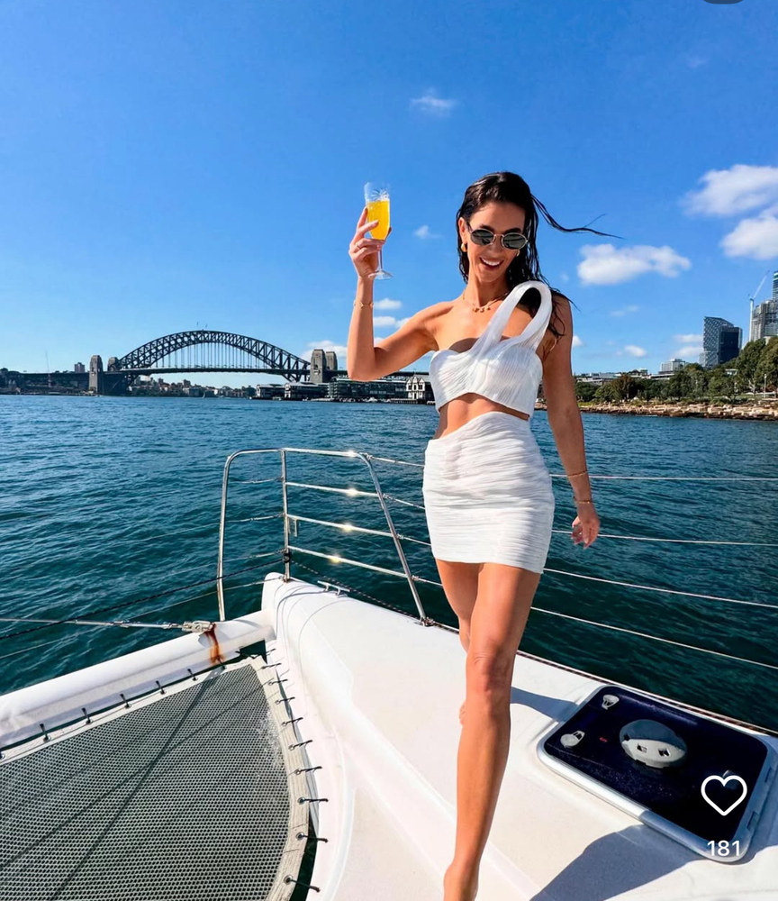 A hen with a drink on the bow of a boat, Sydney Harbour Bridge behind