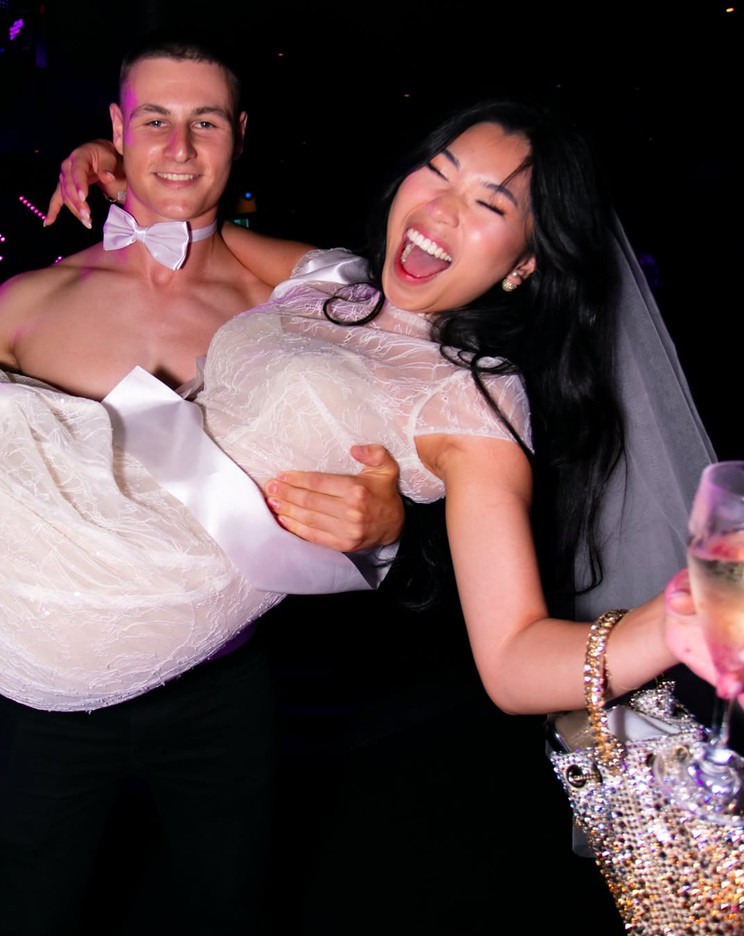 Our topless waiter carrying the bride in her veil while she laughs her head off