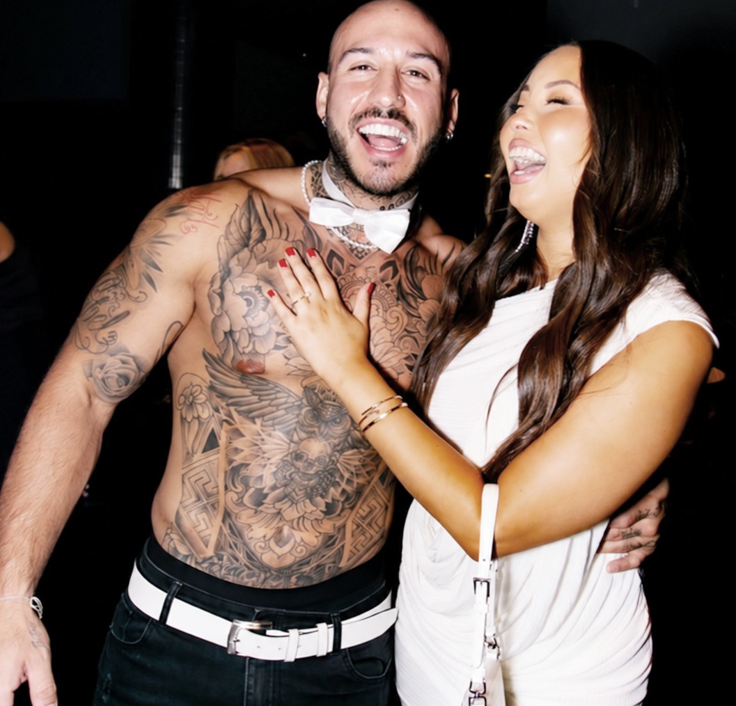 Our tattooed topless waiter in a white bow tie laughing with a hen in white