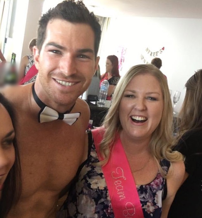 Our topless waiter in his bow tie grinning in a selfie with a laughing hen in a Team Bride sash