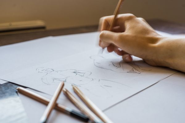 The hen began the life drawing workshop by sketching a male model on white paper with pencils by her side