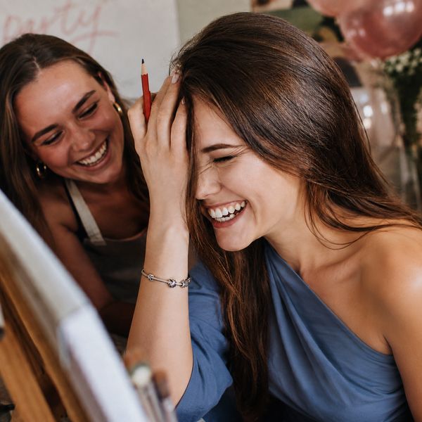 Two friends doubled over laughing at a life drawing class