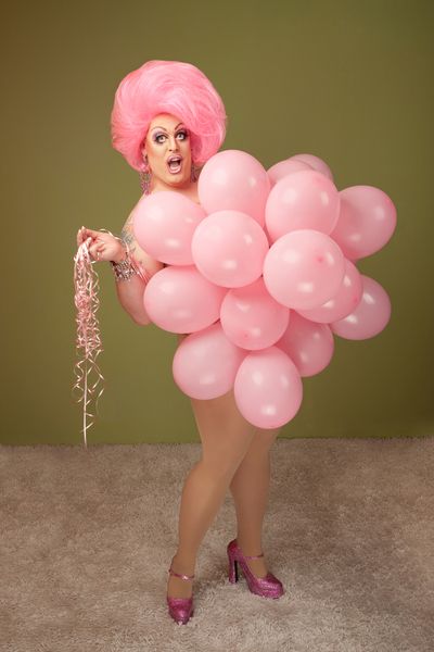 A hilarious drag queen covered in balloons ready to make you laugh