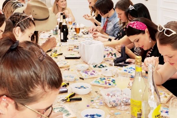 Hens around a long table crafting together with bubbly on the table