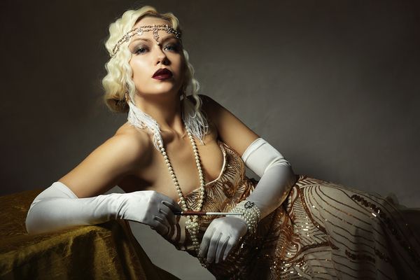 Gorgeous hen dressed in glitzy Roaring Twenties outfit and is seated comfortably for a photo shoot
