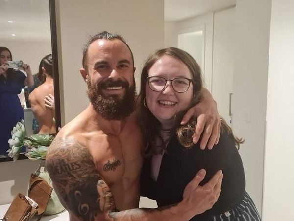A friend hugging the topless waiter in the apartment