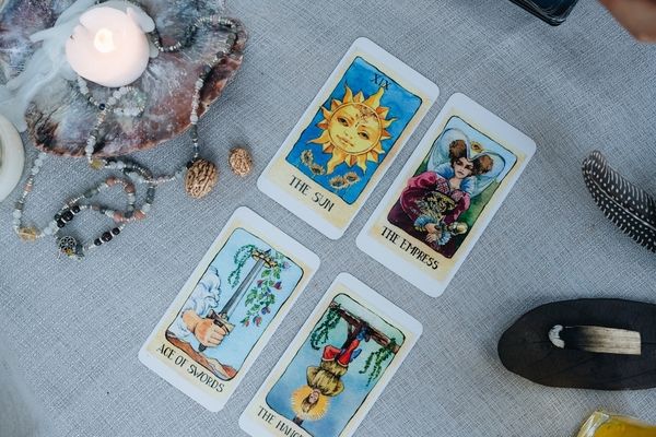 Tarot cards laid out on a linen cloth beside a candle and crystals