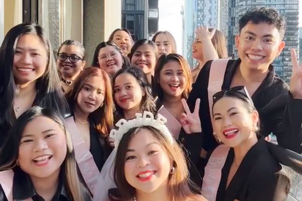 Big group of friends squeezing into a selfie around the bride in a tiara and sash