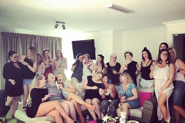 A big group of women laughing together on lounges in a private room
