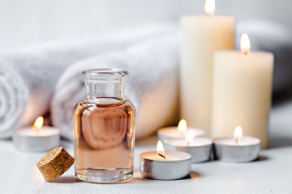 Candles, rolled towels and a bottle of massage oil