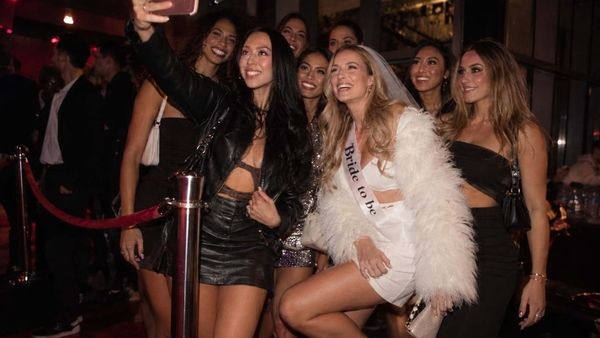 A hens group taking a selfie with the bride to be in her sash at a club