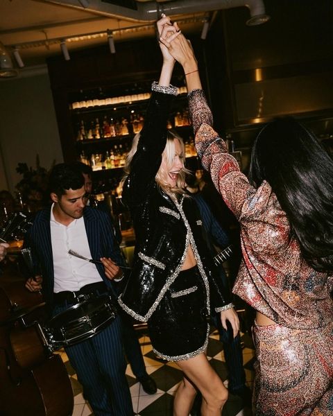Friends dancing with a musician in a dimly lit bar
