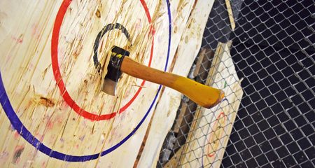 An axe lodged in the centre of a wooden target
