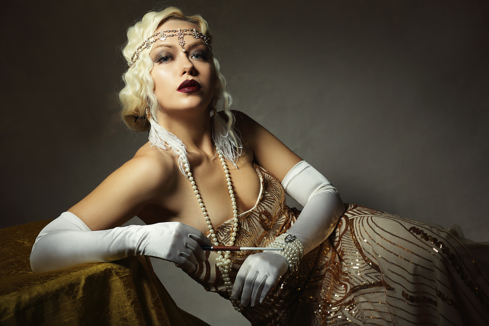 A woman in a 1920s flapper costume with pearls and long gloves