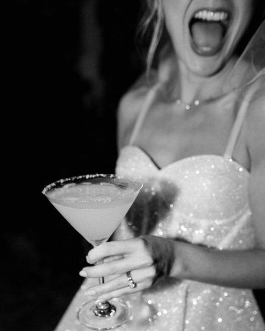 Black and white: a hen in a sequinned dress laughing with a martini in her hand