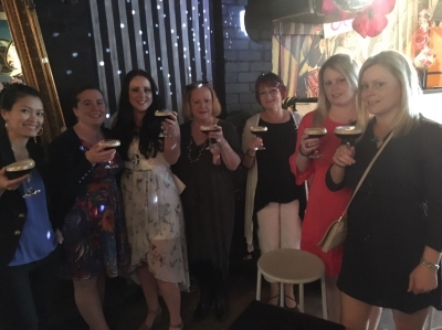 The hens group standing together with drinks on their night out